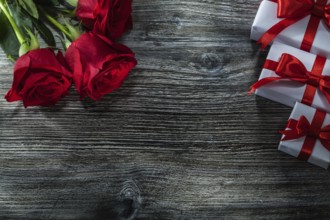White present boxes red roses on wooden board