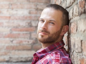 An image of a man portrait at the brick wall