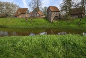 Traditional brick houses by a river, surrounded by green spring landscape, vreden, münsterland,