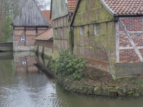 Half-timbered houses with red bricks by the water, surrounded by winter vegetation, aulendorf,