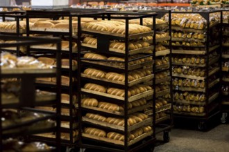 Rack trolley with freshly baked bread at supermarket. Display with fresh bread at bakery shop