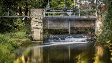 Gundelsheim in Upper Franconia, stream, weir, small bridge with sculpture over a waterfall,