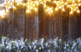 Christmas glowing stars and snow fir on vintage wooden background copy space