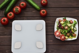 Dieting and control calories for good health concept. salad. smart weight scales. veggies on board.