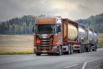 Scania S730 truck of AH-Trans Oy hauls four chemical tank containers on road, ADR codes denoting