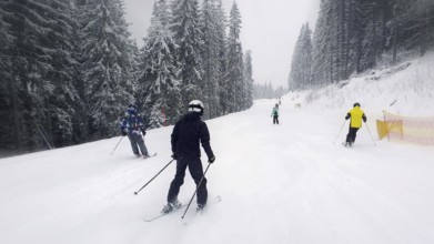 People skiing on the snowy slope of Bukovel ski resort in the Ukrainian Carpathian mountains