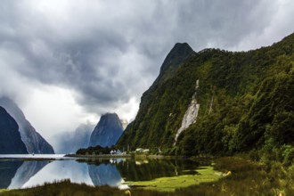 New Zealand. Storm clouds cover the sky over the famous ocean fjord Milford Sound. Port of tourist