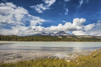 Beneaped Medicine Lake in the fall. Evergreen forests and snow-capped Rocky Mountains of Canada