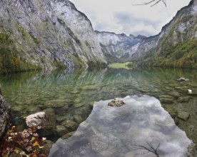 Magic reflection in German lake Koenigssee. Cloudy day on the lake. Clouds and mountains reflected