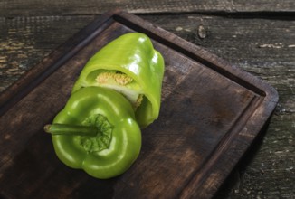 Cut green pepper on wood. Backlight