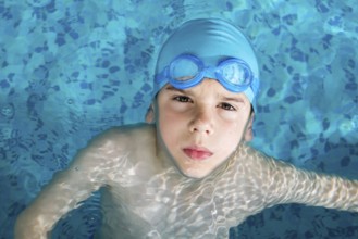 Little boy in swimming pool. Blue swimming pool