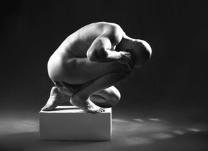 Studio portrait of athletic man. Body sculpture. Monochrome photo