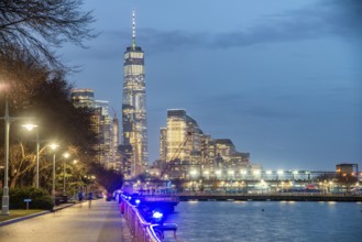 Downtown Manhattan night skyline from Hudson River Park. Skyscrapers lights and city pier