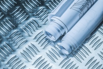 Rolled blueprints on corrugated metal sheet