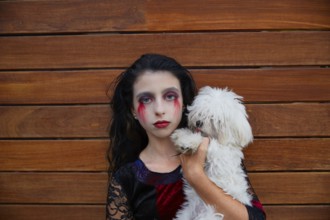 Halloween kid girl custome with bloody makeup on wooden wall