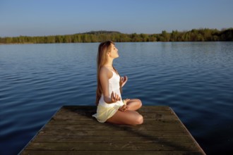 Beautiful young woman doing yoga exercise outdoors