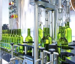 White wine in glass bottling machine at winery