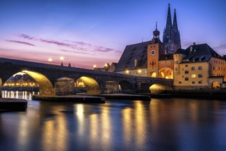 Stone Bridge and St Peter's Cathedral at dusk sunrise in Regensburg with danube