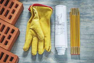 Red bricks leather safety gloves wooden meter construction drawings building concept