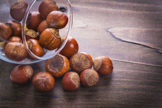 Hazelnuts and glass on vintage wooden board food and drink concept