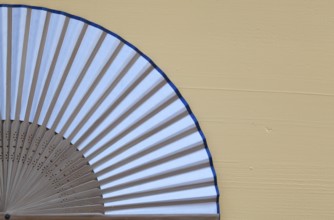 Typical Japanese hand fan made on the wooden yellow table