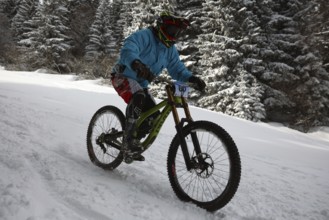 Sofia, Bulgaria - 22 January, 2022: Cyclist rides a bike downhill during an extreme snow riding