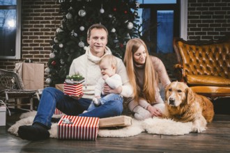 Theme Christmas and New Year family circle and domestic pet. Mom dad and child 1 year old Caucasian