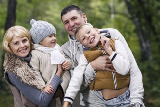 Close up portrait of a young family in the autumn park