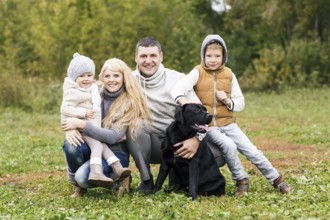 Happy family with dog on nature