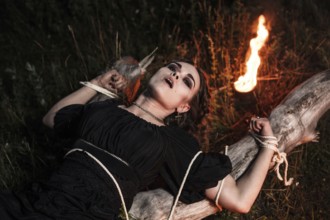 Beautiful young witch in the flames of fire