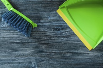 Dustpan and garbage broom set on wooden board