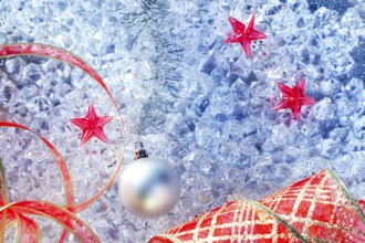 Christmas silver bauble and red ribbon on ice with red star