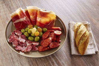 Tapas of Spain with ham bread olives sausage and chorizo on wooden background