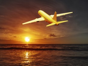 A beautiful sunset over the ocean and an airplane