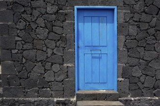 Blue door in black lava stone masonry wall at La Palma Canary Islands