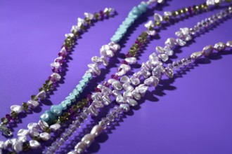Color stones jewelry necklaces, over purple background