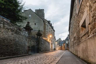 Old cobblestoned street with stone medieval houses in the town centre of Dinan, French Brittany