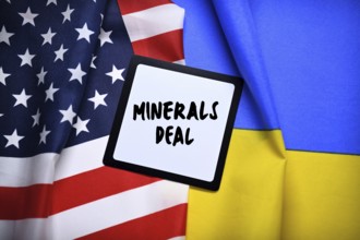 The flags of Ukraine and USA with plaque and inscription minerals deal, photomontage