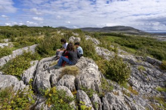 Visitors resting, Burren National Park, The Burren, County Clare, Ireland, United Kingdom, Europe