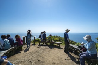 A group of people stand on a viewing platform on Mount Nokogiri in Chiba and look out over the sea