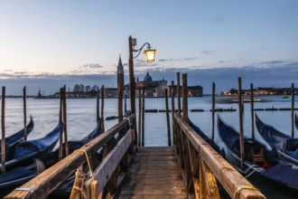 Morning atmosphere, Venetian gondolas with the church of San Giorgio Maggiore in the background,