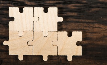 Wooden puzzle on dark wooden background