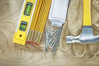 Blueprints construction level safety gloves wooden meter claw hammer nails building concept