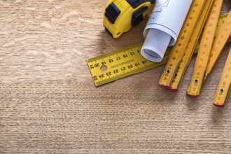 Blueprints and instruments of measurement on oaken wooden board construction concept