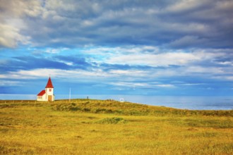 Iceland. White Chapel with red roof on the northern fjord