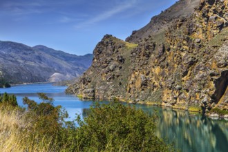The picturesque lake Dunstan near the town of Cromwell. Emerald-colored quiet deep lake water and
