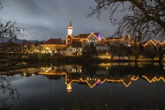 Christmas illuminated house facade of Frohnleiten reflected in the river Mur, Frohnleiten, Styria,