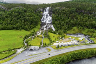 The colossal roaring waterfall Twindefossen. Rainy summer day in the mountains of Norway. Exciting