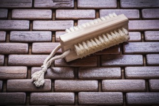 Wood peeling brush on textured wooden matting close up view healthcare concept