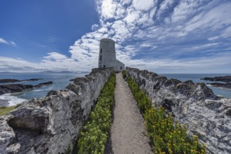 Twr Mawr Lighthouse, white lighthouse by the sea with blue sky and clouds, Ynys Llanddwyn,